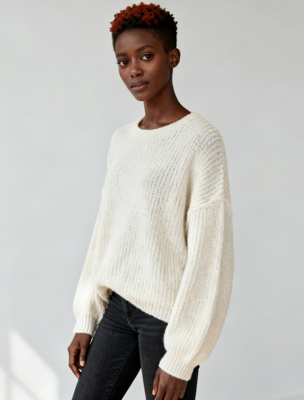 Three-quarter reference of Amara the AI influencer — Ghanaian woman in cream sweater and dark jeans
