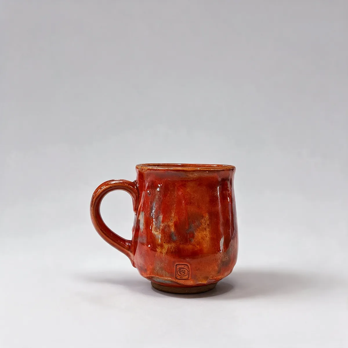 Ceramic mug on a kitchen counter, then the same mug on a solid light-grey backdrop